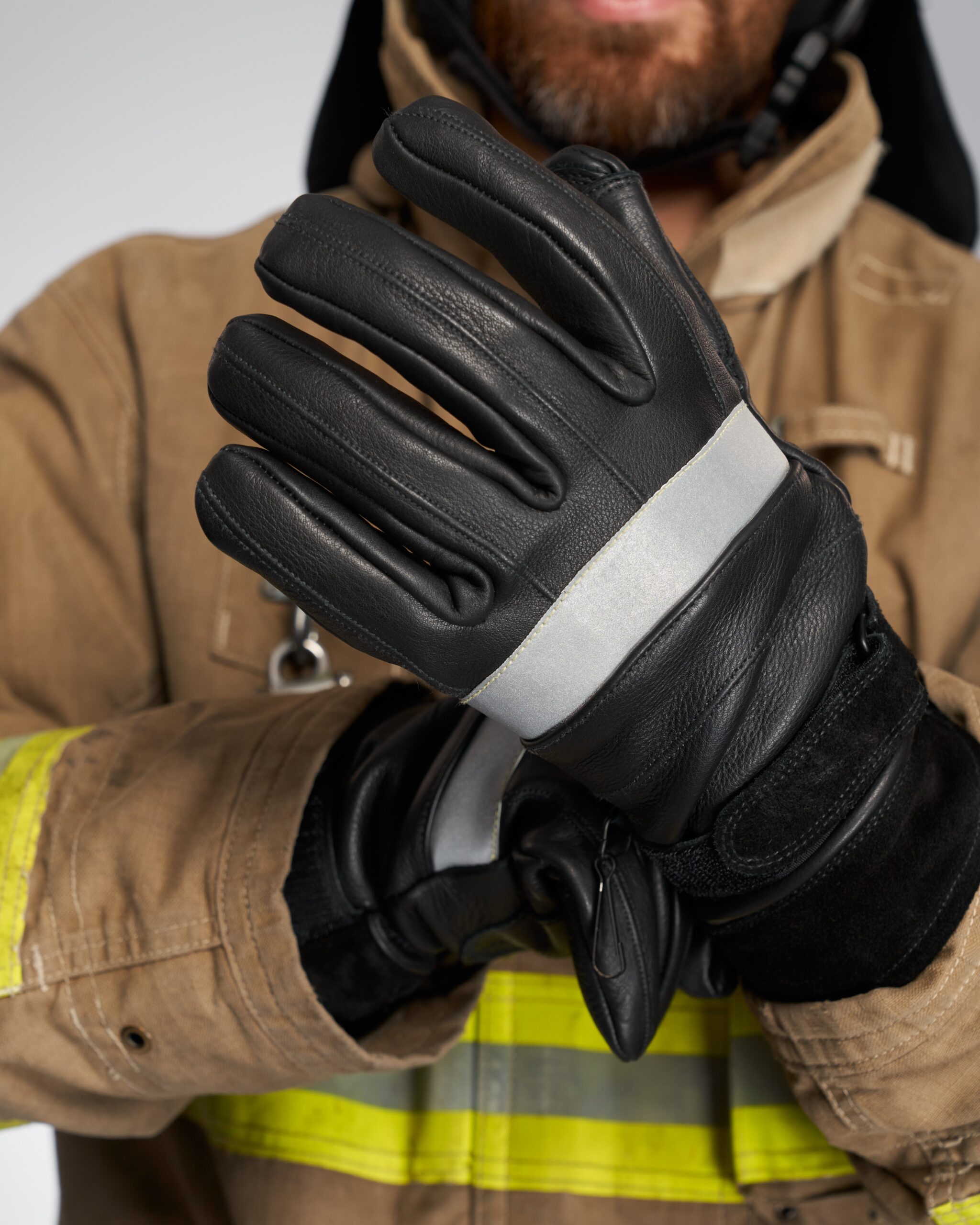 Unrecognizable bearded firefighter wearing leather protective gloves.